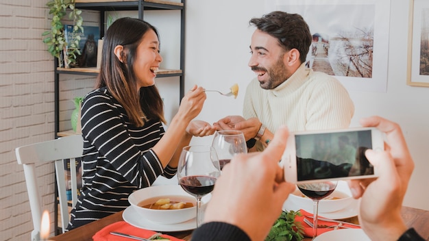 Foto gratuita pareja en cena de navidad por smartphone