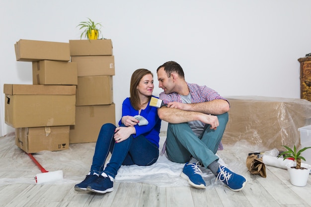 Pareja con cepillos sentado en el piso