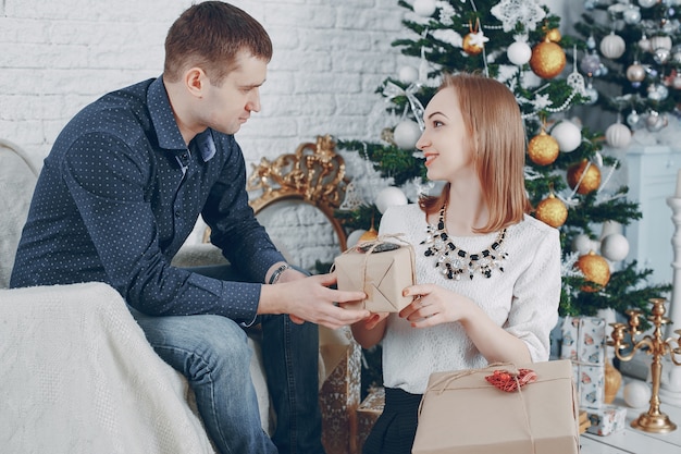 pareja cerca de árbol de navidad