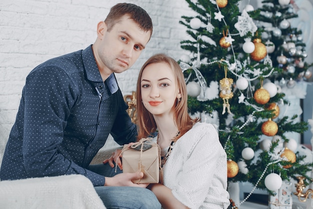 pareja cerca de árbol de navidad