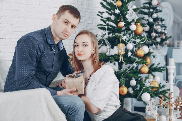 pareja cerca de árbol de navidad