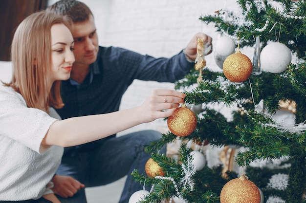 pareja cerca de árbol de navidad