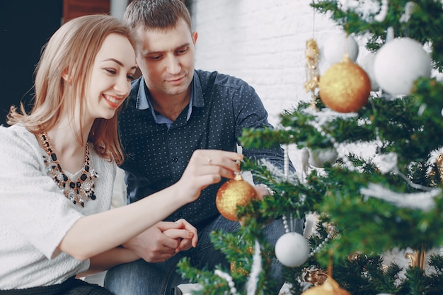 pareja cerca de árbol de navidad