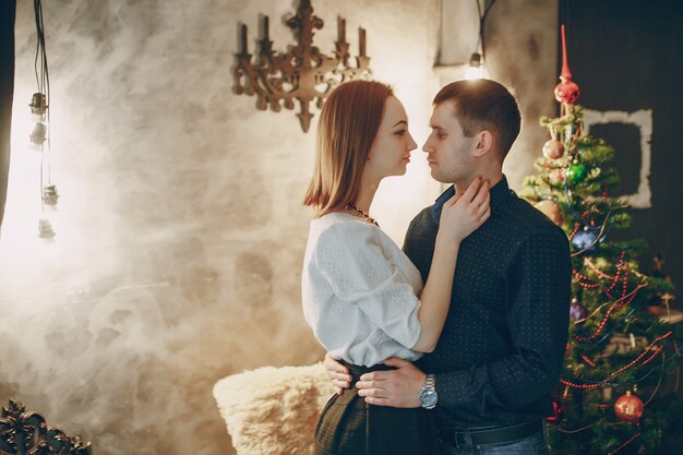 pareja cerca de árbol de navidad