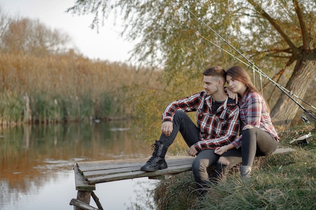 Pareja cerca del río en una mañana de pesca