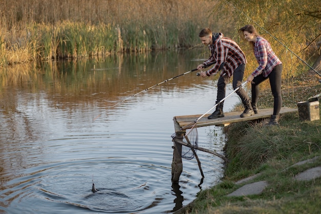 Pareja cerca del río en una mañana de pesca