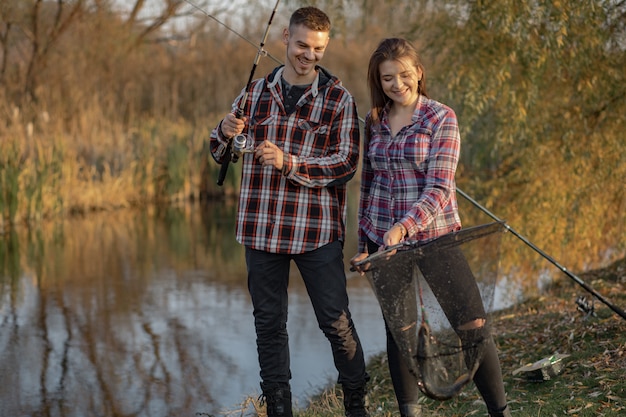 Pareja cerca del río en una mañana de pesca