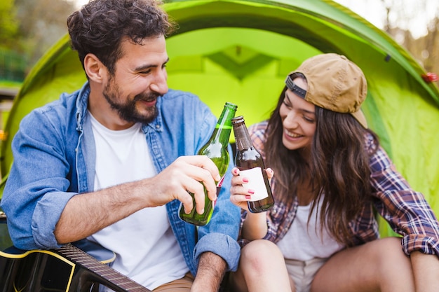 Pareja con cerveza cerca de la tienda