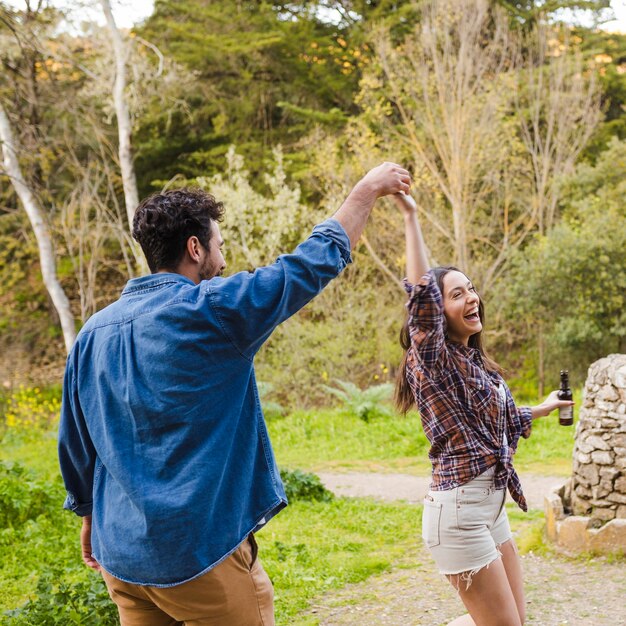 Pareja con cerveza divirtiéndose en la naturaleza