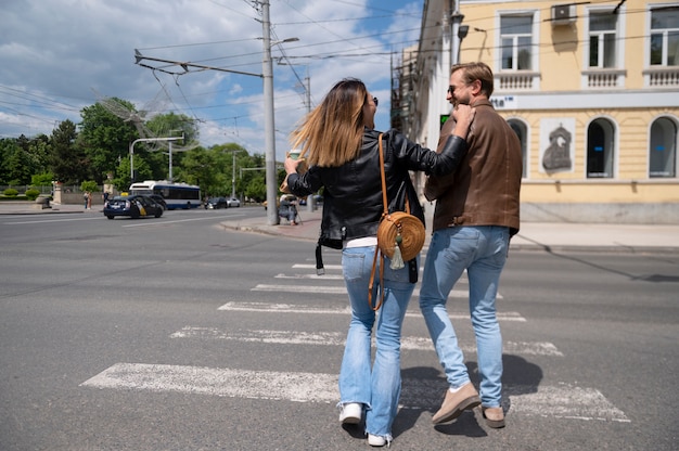 Pareja en chaquetas de cuero sintético caminando juntos por la ciudad