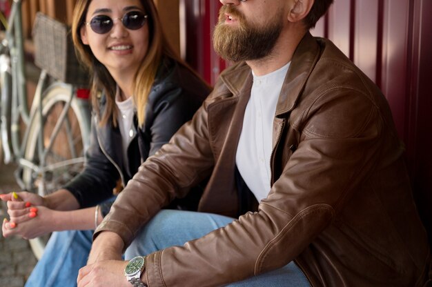 Pareja en chaquetas de cuero sintético pasando tiempo juntos al aire libre