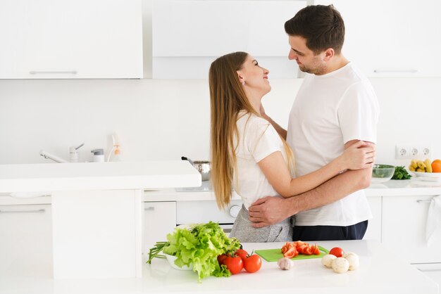 Pareja en la cocina abrazando