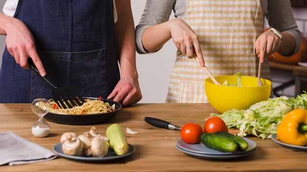 Foto gratuita pareja cocinando en la mesa en la cocina