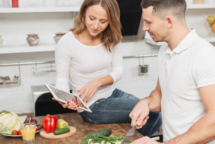 Foto gratuito pareja cocinando con tableta en casa