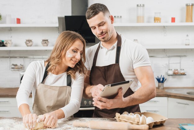 Pareja cocinando con tableta