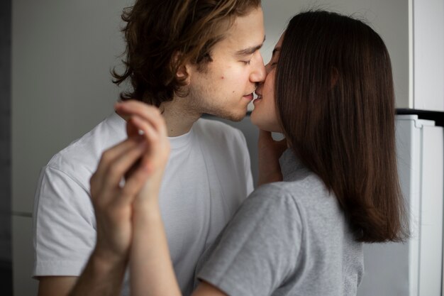 Pareja cogidos de la mano mientras se besan