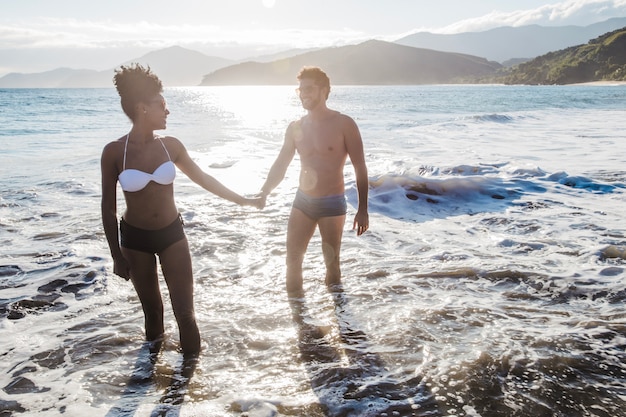 Pareja cogiéndose las manos en la orilla