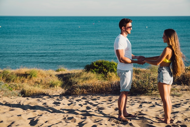 Pareja cogiendose las manos en la playa