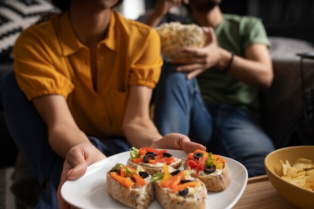 Pareja comiendo juntos en casa en el sofá