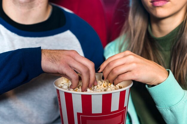 Pareja comiendo palomitas en el cine