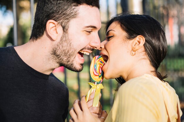 Pareja comiendo piruleta en el parque de atracciones