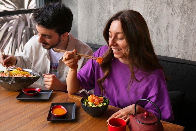 Foto gratuita pareja comiendo plato de salmón en el restaurante