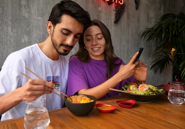 Foto gratuita pareja comiendo plato de salmón en el restaurante