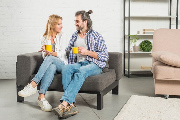 Pareja compartiendo una bebida en el sofá