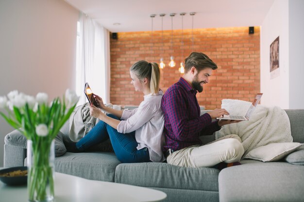 Pareja con computadora portátil y tableta