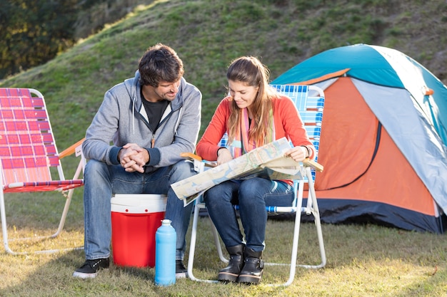 Pareja concentrada estudiando el mapa mientras disfrutan al aire libre