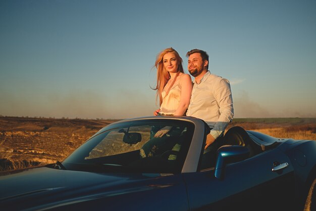 Pareja conduciendo en coche descapotable