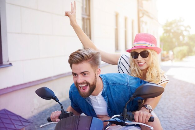 Pareja conduciendo un scooter en la ciudad