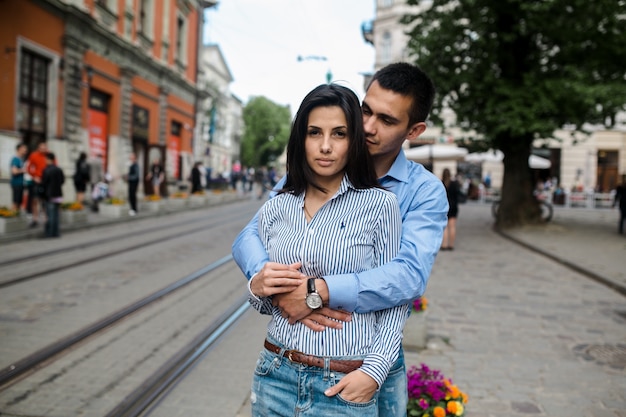 Pareja confidente abrazando en la calle