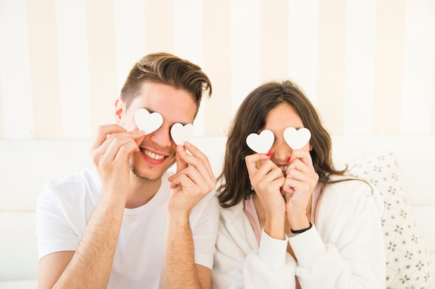 Foto gratuita pareja con corazones cerca de los ojos