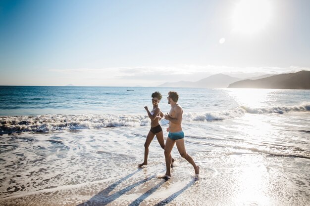 Pareja corriendo por el agua