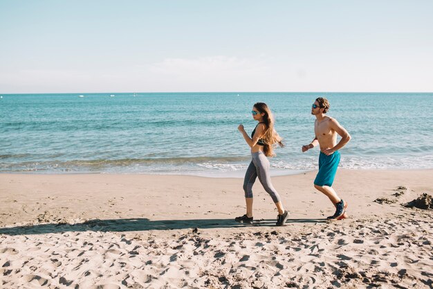 Pareja corriendo por la playa