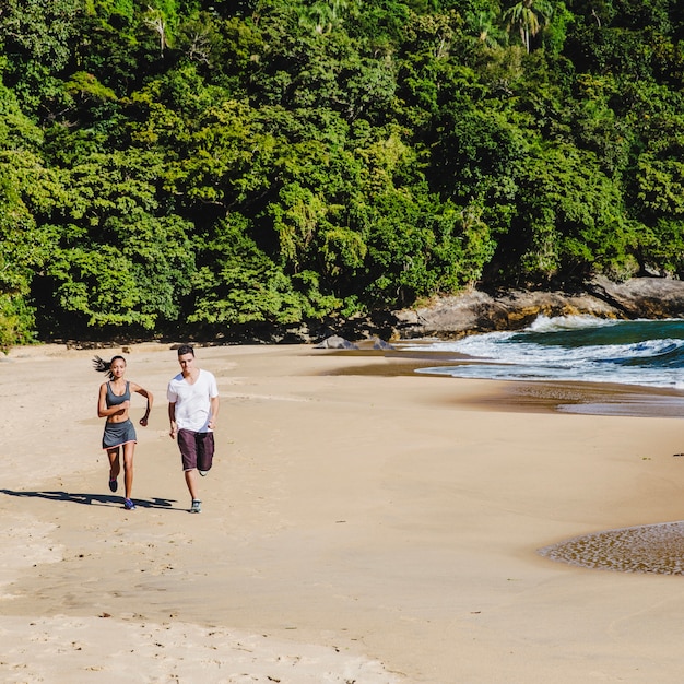 Pareja corriendo en la playa