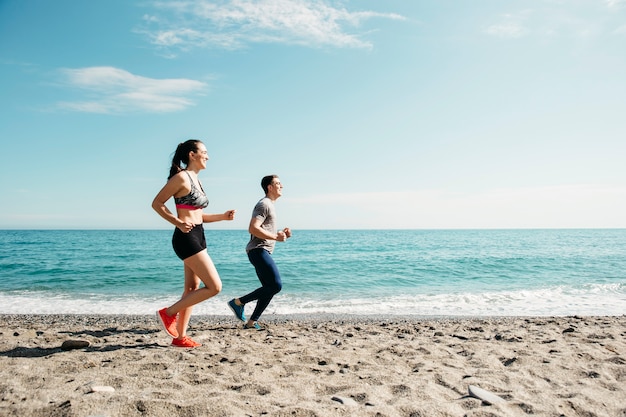 Pareja corriendo en la playa