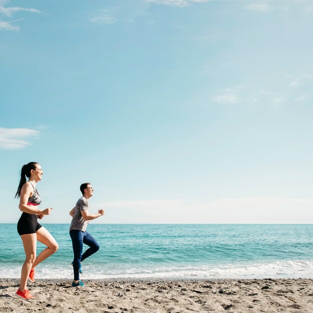 Pareja corriendo en la playa