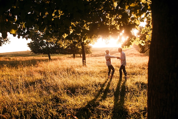 Pareja corriendo hacia la puesta de sol