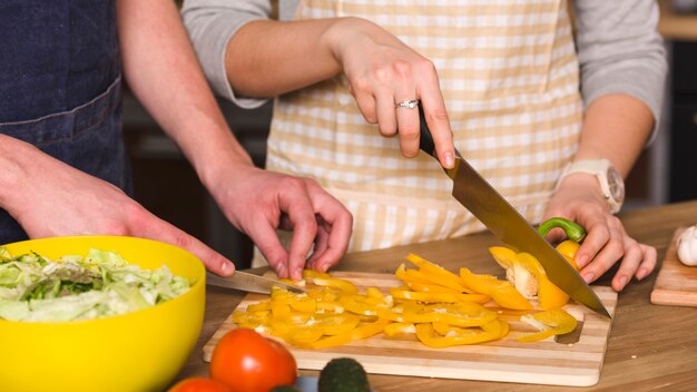 Pareja cortando pimiento amarillo