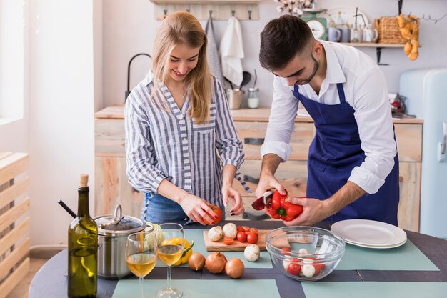 Pareja cortando verduras para ensalada a bordo