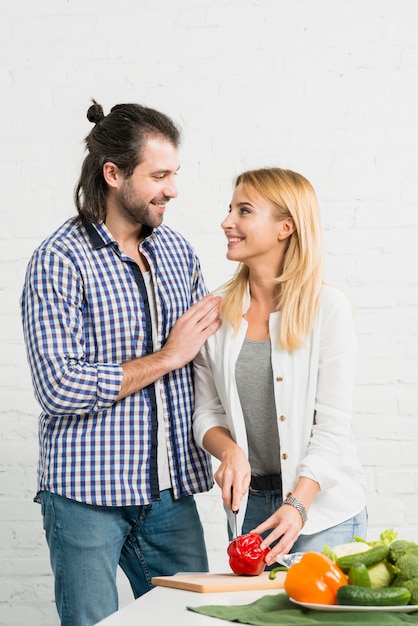 Pareja cortando verduras