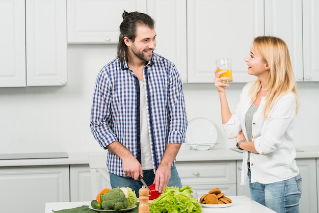 Pareja cortando verduras