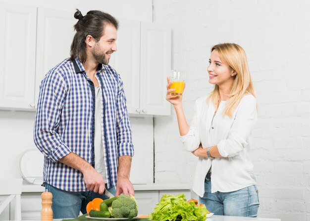 Pareja cortando verduras