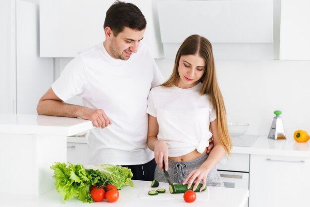 Pareja cortando verduras