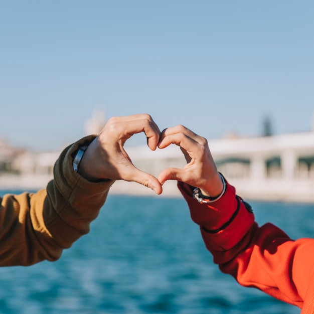 Foto gratuita pareja de cosecha que muestra el corazón con las manos