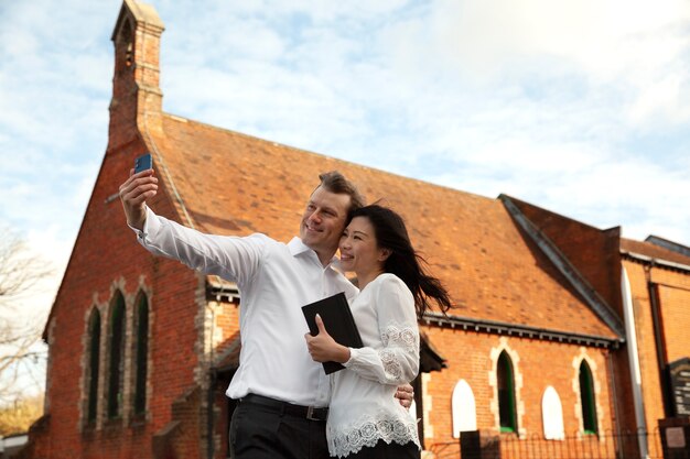 Pareja cristiana de tiro medio tomando selfie