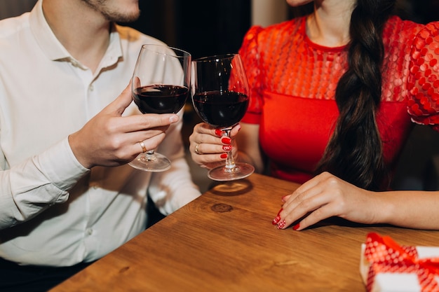 Pareja de cultivo tintineo con copas de vino