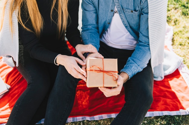 Pareja de cultivos con caja de regalo afuera